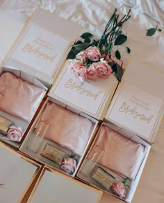 pink roses are sitting on the bed next to boxes with personalized items in them