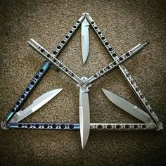 four different types of knives are arranged in a triangle on the floor with chains around them