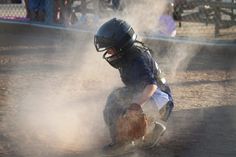 a young baseball player kneeling down in the dirt