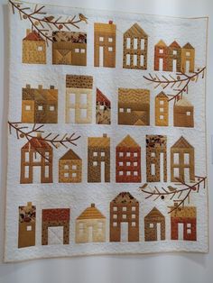 a quilted wall hanging with houses on it