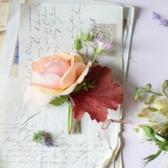 an old letter with flowers on it next to some other papers and paper clippings