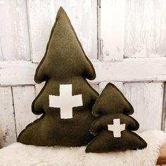 two green christmas trees with white crosses on them