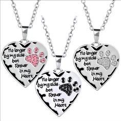 two heart shaped pendants with dog paw prints on the front and back of them