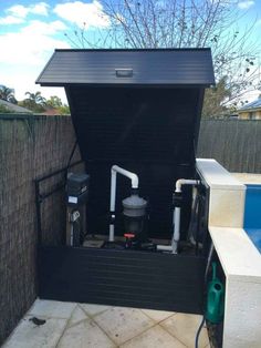 an outdoor pool with a black cover and two water pumps