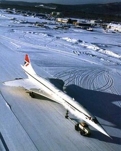 an airplane that is sitting on the ground in the middle of some snow covered ground