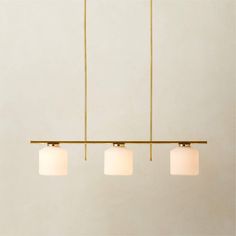 three lights hanging from a ceiling fixture in a room with white walls and flooring