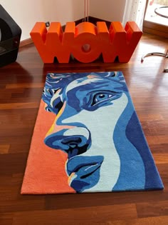 a rug with the word wow on it in front of an orange and blue carpet