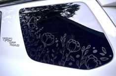 a white car with flowers painted on it's side window