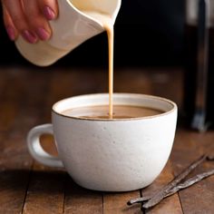 a person pours coffee into a white cup