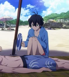 a person laying on the ground with an umbrella in front of him and another person standing behind them