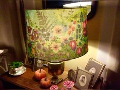 a lamp that is sitting on top of a table next to pictures and other items