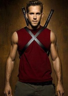 a man with two swords on his head standing in front of a brown background and wearing a red shirt