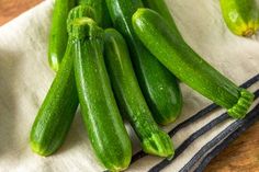 green cucumbers are sitting on a cloth