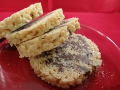 two cookies are stacked on top of each other in front of a red tablecloth