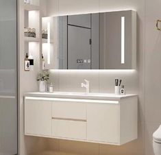 a bathroom with a sink, mirror and toilet in it's center area is shown