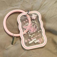 a pink and black cell phone case with writing on the front, attached to a rubber ring