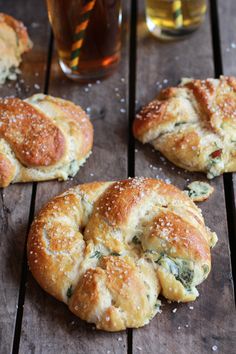 some breads are sitting on a wooden table next to a glass of tea and a drink