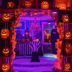 an entrance to a house decorated for halloween with pumpkins and jack - o'- lanterns