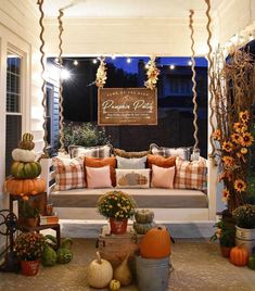 a porch decorated for fall with pumpkins and gourds