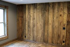 an empty room with wood paneling on the walls