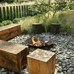 a fire pit surrounded by wooden benches and rocks