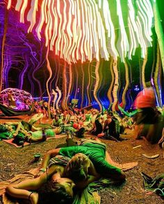 people laying on the ground in front of colorful lights