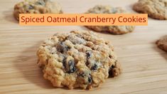 several cookies on a wooden table with the words spiced oatmeal cranberry cookies