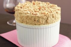 a close up of a cake on a plate near a wine glass and napkins