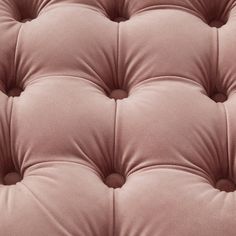 a close up view of the back end of a pink couch cushion with buttons on it