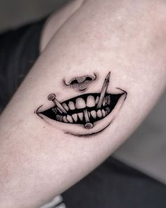 a close up of a person's arm with a tattoo on it that looks like a smiling face