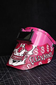 a pink helmet with a skull and dollar signs on it