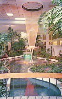 an indoor swimming pool surrounded by trees and plants