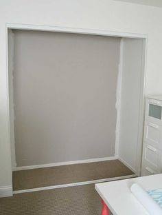 an empty room with white walls and carpeted flooring is seen in this image