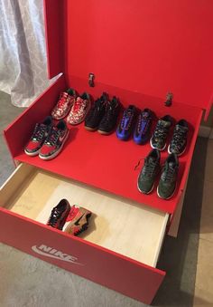 there are many pairs of shoes in the red shoe box on the floor next to each other