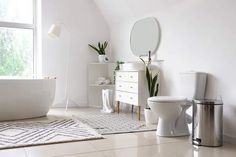 a white bathroom with a tub, toilet and sink