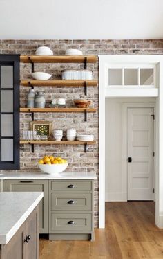 a brick wall in a kitchen with open shelving