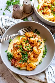 two bowls filled with shrimp and grits on top of a table