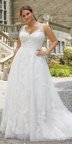 a woman in a white wedding dress posing for the camera with her hands on her hips