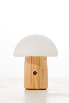 the mushroom lamp is made out of wood and has a white light on it's side