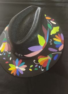 a black hat with colorful flowers painted on it