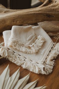 a table topped with white napkins and other items on top of a wooden table