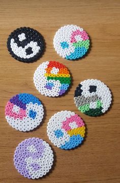 six different types of beaded buttons on a wooden table with one being an emo