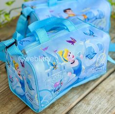 a blue bag with princesses on it sitting on top of a wooden table