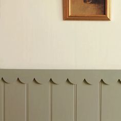 a painting on the wall above a radiator in a room with beige paneling