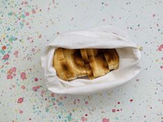 a bag filled with bread sitting on top of a table