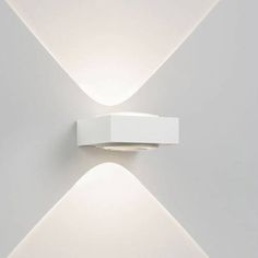 a white wall mounted light on the side of a building