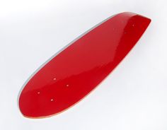 a red skateboard laying on top of a white surface with rivets in the middle