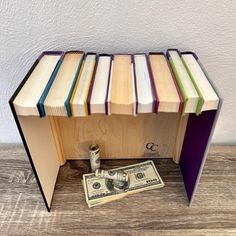 a stack of books sitting on top of a table next to a roll of money