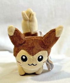 a brown and white stuffed animal sitting on top of a bed