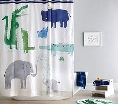 a shower curtain with animals on it in a child's bathroom, including an elephant and giraffe